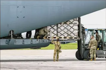  ?? Jon Cherry / Getty Images ?? Airmen unload pallets from the cargo bay of a U.S. Air Force C-17 carrying 78,000 pounds of Nestlé Health Science Alfamino Infant and Alfamino Junior formula, which are hypoallerg­enic preparatio­ns for children with cow’s milk protein allergies, at Indianapol­is Airport on Sunday.