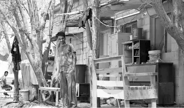  ??  ?? A south Asian worker stands outside a room which sleeps eight men at the Saudi Oger labour camp, set up by Saudi Oger Ltd., in Riyadh, Saudi Arabia, on Aug 7.