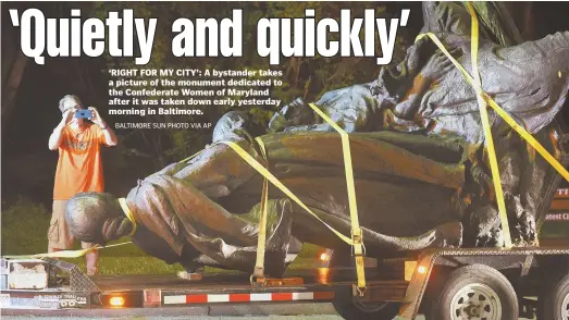  ?? Baltimore Sun PHoto via aP ?? ‘RIGHT FOR MY CITY’: A bystander takes a picture of the monument dedicated to the Confederat­e Women of Maryland after it was taken down early yesterday morning in Baltimore.