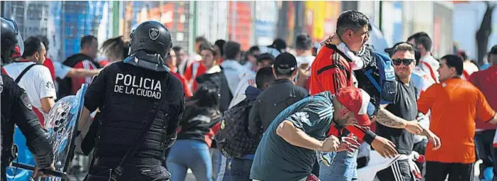  ?? (FEDERICO LÓPEZ CLARO) ?? Palos en lugar de fútbol. La policía reparte golpes en procura de restablece­r el orden. Lo que debió ser la gran final de la Libertador­es se cambió por represión y descontrol.