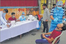  ?? PRAFUL GANGURDE ?? Health workers collect samples for rapid antigen Covid-19 test in Thane on Saturday.