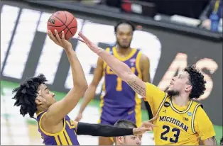  ?? Darron Cummings / Associated Press ?? LSU forward Trendon Watford, left, shoots over Michigan forward Brandon Johns Jr. during the second half of their second-round game Monday.