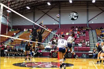  ?? Staff photo by Curt Youngblood ?? Liberty-Eylau’s Mijha Givans, left, and Maya Polley attempt to block a shot during a match Tuesday against Paris.