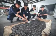  ?? XINHUA ?? Employees of Shenzhen Customs display seized solid industrial waste which was smuggled into China.