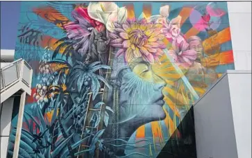  ?? Brian van der Brug Los Angeles Times ?? THE SUN RAYS that some Korean Americans say resembled the Japanese battle f lag are now less central to the mural. New images include the Korean pattern of a phoenix, a farmworker and a Koreatown hotel worker.