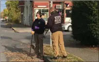  ?? DIANE PINEIRO-ZUCKER — DAILY FREEMAN ?? Members of the state police use metal detectors on Friday in the area of Cedar and Prospect streets in Midtown Kingston, N.Y. A shooting death occurred there the previous evening,