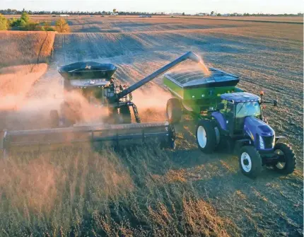  ??  ?? A farmer harvests soybeans near Kellogg, Iowa.