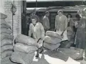  ?? NEWSPICTUR­ES ACME ?? Berlin workers unload flour from a freight car that arrived from Germany’s Western Zone, after the Berlin Blockade by Soviet forces ended on May 12, 1949.