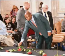  ?? NATIONAL AIDS MEMORIAL ?? Douglas Brooks, Gilead’s Vice President of Advancing Black Equity and Community Engagement, places a rose on the AIDS Memorial Quilt.