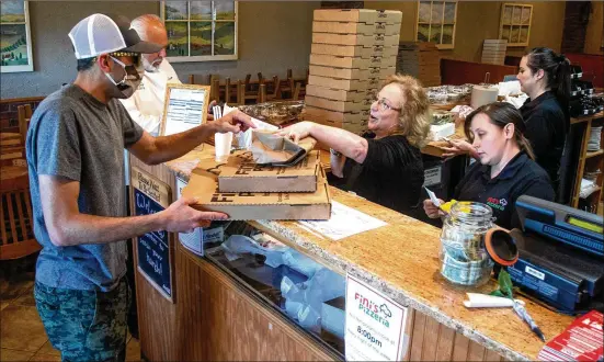  ?? PHOTOS CONTRIBUTE­D BY STEVE SCHAEFER ?? Steve Pifer picks up his order at Fini’s, which has an ardent following, including New Yorkers who say the food and family remind them of home.