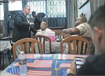  ?? Wally Skalij Los Angeles Times ?? SHERIFF’S candidate Bob Lindsey talks to patrons at Nkechi African Cafe in Inglewood on Friday. He has more money, about $740,000, backing him than Sheriff Jim McDonnell does, about $586,000.
