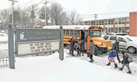  ?? BARBARA J. PERENIC/COLUMBUS DISPATCH ?? Students arrive at Clinton Elementary School by car, bus and on foot on Feb.18. School officials announced on Thursday that students in grades 6, 11 and 12, divided in two groups, will return to in-person learning on March 15 and March 18. Meanwhile, students in grades 7, 8, 9 and 10 will return on March 22 and March 25.