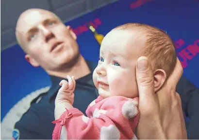  ?? ROBERTO E. ROSALES/JOURNAL ?? Albuquerqu­e police officer Ryan Holets holds his adopted daughter, Hope, who is 8 weeks old. The baby’s mother was eight months pregnant and shooting up heroin when Holets met her. He later offered to adopt her unborn baby.