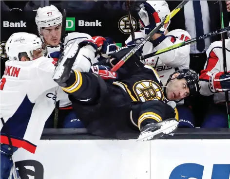  ?? ELISE AMENDOLA/THE ASSOCIATED PRESS ?? Bruins defenceman Zdeno Chara tumbles into the Capitals bench courtesy of an Alex Ovechkin check during action in Boston on Thursday. Chara might not be as physical as he once was, but at age 41 he remains one of the league's best on the blue-line.