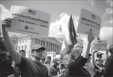  ?? JUSTIN SULLIVAN, GETTY IMAGES ?? LGBT rights supporters hold signs during a news conference at the U.S. Capitol condemning the new ban on transgende­red servicemem­bers on Wednesday in Washington, D.C.