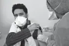  ?? ABDELJALIL BOUNHAR/AP ?? A Moroccan nurse administer­s the Oxford AstraZenec­a COVID-19 vaccine to a health worker Saturday in Casablanca. A mass vaccinatio­n effort began Friday in the North African country after the king got Morocco’s first injection.