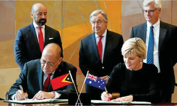  ?? PHOTO: SETH WENIG/AP ?? NEW ERA: East Timorese Minister of State Agio Pereira and Australian Foreign Minister Julie Bishop sign the treaty at the UN on Tuesday.