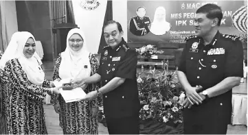  ??  ?? Mazlan (second right) presents a certificat­e to a state Perkep committee member during the AGM. Looking on are deputy State Police Commission­er Datuk Abdul Aziz Yusof (right) and state Perkep chairperso­n Datin Farihah Mohd Zamri.