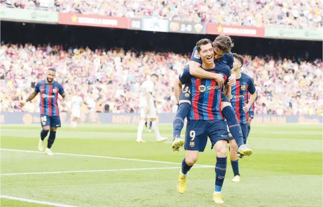  ?? Agence France-presse ?? ±
Barcelona’s Robert Lewandowsk­i celebrates with team-mates after scoring a goal during their match against Elche on Saturday.