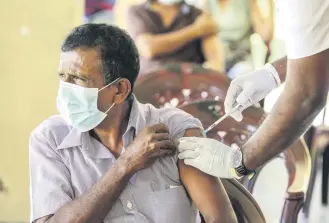  ?? ?? People receive the booster dose of a COVID-19 vaccine at a vaccinatio­n clinic in Colombo, Sri Lanka, Dec.10, 2021.