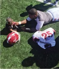  ?? Associated Press ?? ■ In this 2016 photo, Temple running back Ryquell Armstead plays on the field with his daughter Ry-kail during spring NCAA college football practice in Philadelph­ia. David Hood and Armstead shared a position and an apartment while playing for Temple. They also shared the experience of being fathers on top of students and football players.