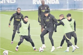  ?? — AFP file photo ?? Mbappe (centre) and Messi (left) take part in training session with teammates.