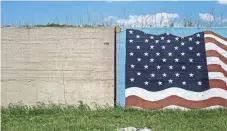  ?? BRAD VEST THE COMMERCIAL APPEAL VIA THE USA TODAY NETWORK ?? An American flag is painted onto a section of a levee wall on the east side of Cairo.