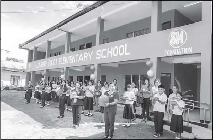  ??  ?? School officials, teachers and students show a special presentati­on during the new building’s turnover.