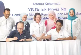  ?? ?? Measat’s Yau (seated, left) and Mudah Healthtech chief executive officer Datuk Dr Kantha Rasalingam (seated, right) during the MOU signing ceremony witnessed by Flovia (middle) in Kg Togop Darat, Ranau in Sabah.