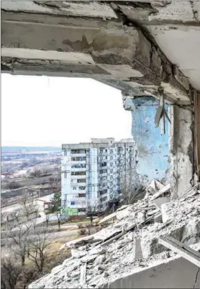  ?? DMYTRO SMOLIYENKO / ABACA PRESS ?? A woman takes photos in a damaged building in Zaporizhzh­ia, Ukraine on numerous people, aggravated geopolitic­al confrontat­ion in Europe, intens internatio­nal security.