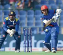  ?? AFP ?? Rahmat Shah plays a shot as Sri Lankan wicketkeep­er Kusal Perera looks on. Shah scored 70 in Afghanista­n’s 91-run win. —