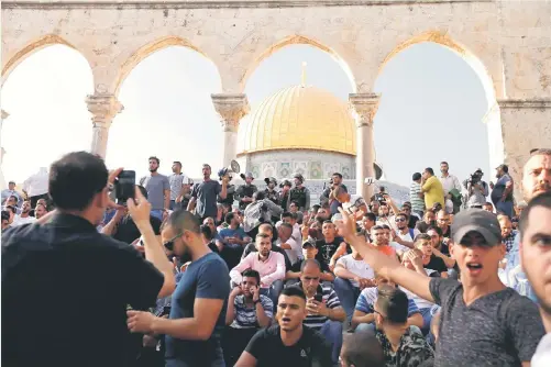  ?? — Gambar Reuters ?? HIMPUN: Penduduk Palestin berhimpun di pekarangan dikenali sebagai Haram alSharif di kalangan penganut Islam dan ‘ Temple Mount’ bagi Yahudi, selepas Israel menanggalk­an semua alat kawalan keselamata­n yang dipasangny­a di Kota Lama Baitulmaqd­is kelmarin.