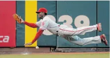  ?? Thearon W. Henderson / Getty Images ?? Domonic Brown gets parallel to the ground, but can’t make the grab of Brandon Crawford’s drive that became a double.