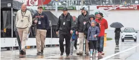  ?? MATTHEW O’HAREN/USA TODAY SPORTS ?? NASCAR fans walk on pit road while rain falls at Dover Internatio­nal Speedway on Sunday in Delaware.