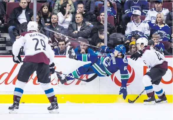  ?? DARRYL DYCK/THE CANADIAN PRESS ?? Canucks forward Tyler Motte is upended by Colorado Avalanche blue-liner Samuel Girard while Nathan MacKinnon looks on Friday night at Rogers Arena.