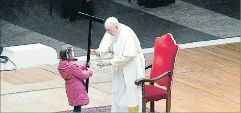  ?? VATICAN MEDIA HANDOUT / EFE ?? El papa Francisco recibe la cruz de una niña en la plaza, casi desierta, de San Pedro del Vaticano