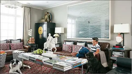  ?? AP/DAVID A. LAND for VERN YIP ?? Interior designer Vern Yip sits on a couch with his dogs in his home in Atlanta. With progress in technology, durable rugs made with antimicrob­ial, stain-resistant fibers have become much more pleasant to the touch and are available in a wide range of...