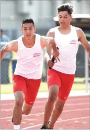  ?? RECORDER PHOTO BY CHIEKO HARA ?? Lindsay High School's anchor Richie Hernandez, left, receives a baton from Chris Orozco in the boys 4x100-meter relay Wednesday in Lindsay.