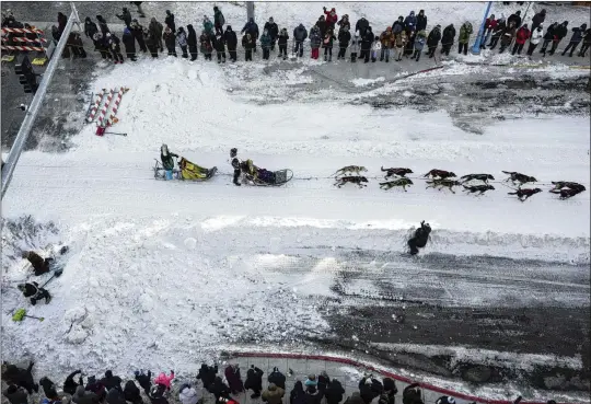  ?? AP PHOTOS 2024 ?? A musher leaves downtown Anchorage, Alaska, on March 2 during the ceremonial start of the Iditarod Trail Dog Sled Race. Though dog mushing has a long and storied tradition in Alaska, the deaths of three dogs during the race — and five more during training — have refocused attention on the sport’s darker side, raising questions about the ethics of the race.