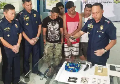  ?? —CONTRIBUTE­D PHOTO ?? BUSTED Senior Supt. Rhoderick Armamento (right), Quezon provincial police chief, inspects the guns seized from suspected drug users who have reportedly been recruited by syndicates as pushers. Supt. Arturo Brual (second, from left), Lucena City police...