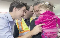  ?? NATHAN DENETTE / THE CANADIAN PRESS FILES ?? Prime Minister Justin Trudeau greets refugees fleeing the Syrian civil war last December at Pearson Airport.