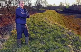  ??  ?? DIY defence: Farmer John Flintoff stands on his soil mound