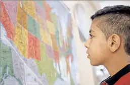  ??  ?? New home: Syrian refugee Hamzeh Jouriyeh, 12, looks at San Diego, where his family is going to live, on a map in a migrants’ office in Jordan.