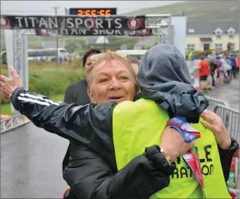  ??  ?? Áine Long is welcomed home to Dún Chaoin after crossing the finishing line in The Kerryman Dingle Half Marathon on Saturday Photo by Declan Malone