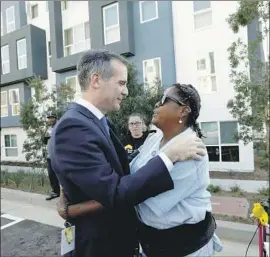  ??  ?? L.A. MAYOR ERIC GARCETTI greets Big Mama at the grand opening of new apartments in October. Nearly a year later, she is grateful but not free of worry.