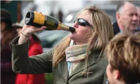  ??  ?? A racegoer swigs from a bottle of prosecco during Ladies’ Day at the Cheltenham festival. Photograph: Joe Giddens/PA