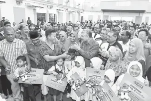  ?? — Gambar Bernama ?? PENYERAHAN SUMBANGAN: Zahid (tengah) beramah mesra bersama penjaga penerima sumbangan Skim Simpanan Pendidikan Nasional 1Malaysia (SSPN1M) selepas penyerahan sumbangan di Dewan Dato’ Mohamed Jamrah, Sg Sumun, Bagan Datuk, semalam.