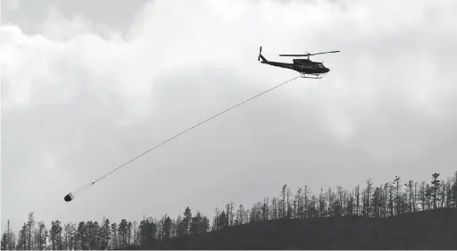  ?? — Gambar Reuters ?? PADAM API: Helikopter turut menyertai usaha memadamkan kebakaran hutan di bandar Cache Creek, British Columbia di Kanada pada 18 Julai.