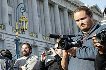  ?? ERIC RISBERG / AP ?? David DePape, right, records the nude wedding of Gypsy Taub outside City Hall on Dec. 19, 2013, in San Francisco.