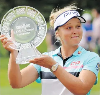  ?? CORY OLSEN/ASSOCIATED PRESS ?? Brooke Henderson with the winner’s trophy after winning the Meijer LPGA Classic by two strokes Sunday at Blythefiel­d Country Club in Grand Rapids, Mich.